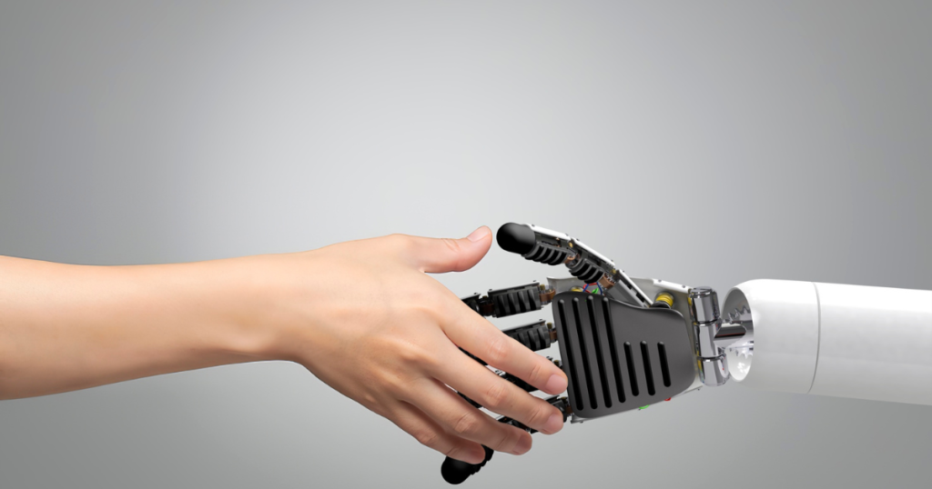 A human hand shaking hands with a robotic hand, symbolizing the collaboration between Artificial Intelligence and humans in modern technology.